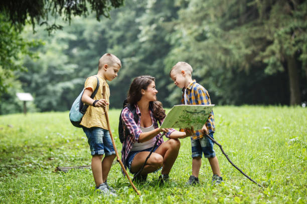 istock Mother and her little sons hiking .They taking a break and examining map. 1314963098
