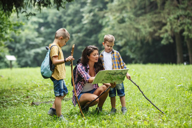 istock Mother and her little sons hiking .They taking a break and examining map. 1314963107