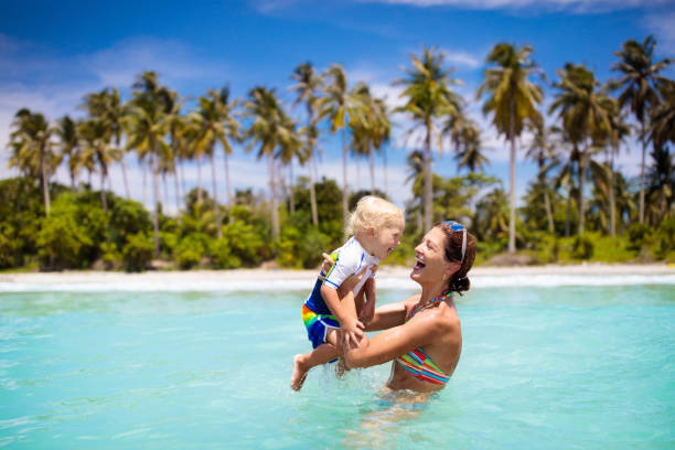 madre y bebé en la playa tropical. los niños nadan. - family beach vacations travel fotografías e imágenes de stock