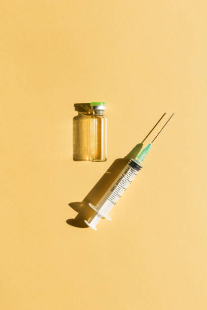 注射器と注射ボトルは黄色の背景にあります - syringe vaccination vial insulin ストックフォトと画像