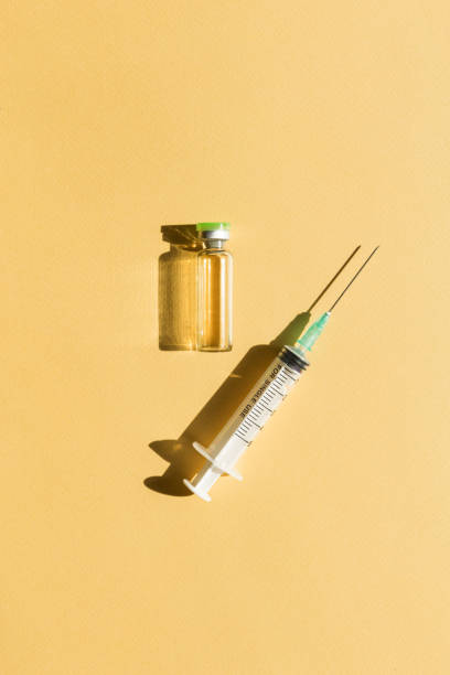 syringe and injection bottle lie on yellow background - syringe vaccination vial insulin imagens e fotografias de stock