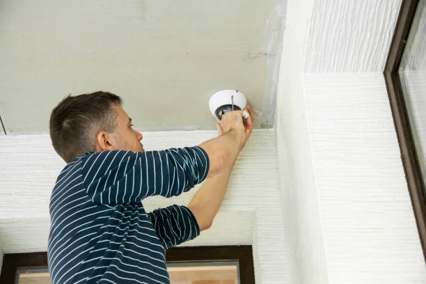 istock Man installs security camera in private house under construction 1314971450