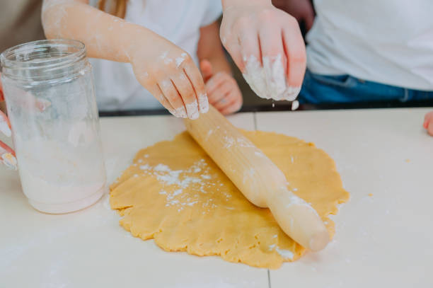 istock Mom teaches her daughters to cook dough in the kitchen. 1314974116
