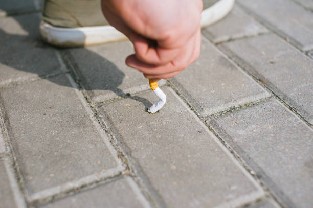 istock A man puts out a cigarette on the sidewalk tiles. 1314975191