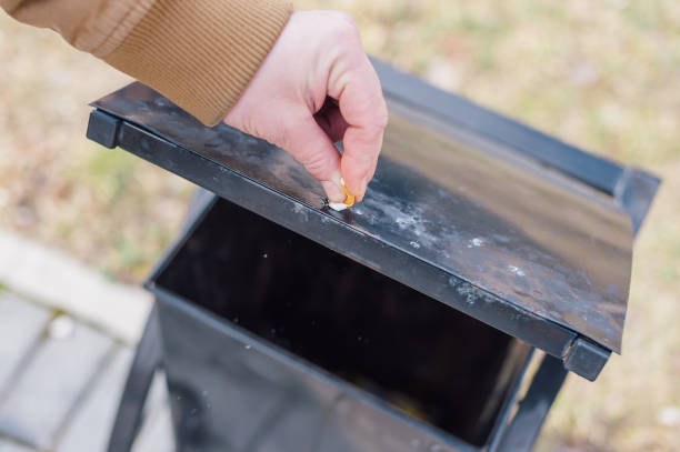 istock A man puts out a cigarette in the trash. 1314975203