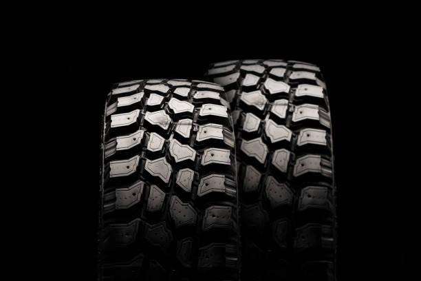 istock two mud tires on a black background, powerful dirt tread for off-road driving 1314975350