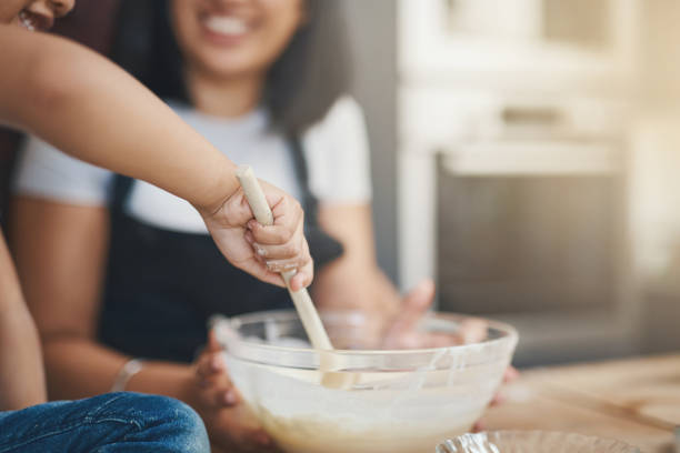 Shot of a woman and her young son baking together at home