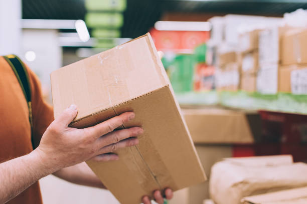 istock A man in a store holds a brown box in his hands. 1314978180