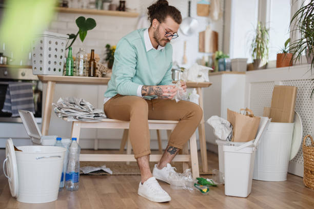 istock Man throwing plastic bottles into recycle bin at home 1314979190