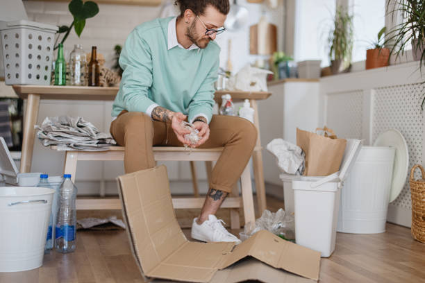 Young man separates plastic tape from cardboard. Recycling