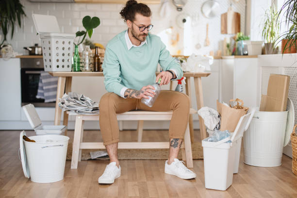 istock Man throwing plastic bottles into recycle bin at home 1314979245