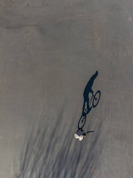istock Long shadow of a man on a bicycle on the asphalt 1314979819