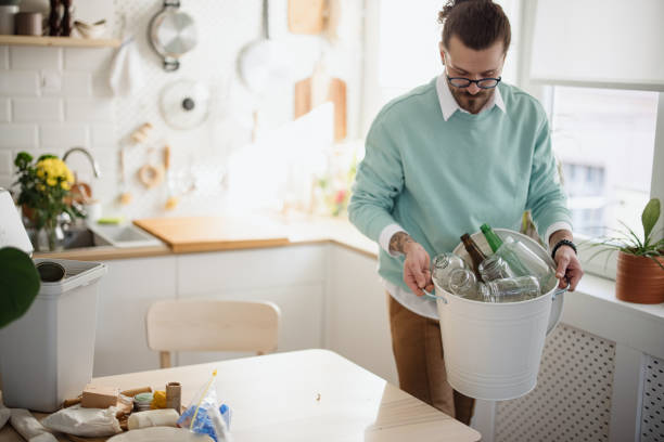 istock Man separating garbage in recycle bins in the kitchen 1314979834