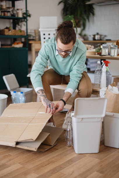 istock Young man separates plastic tape from cardboard. Recycling 1314980037