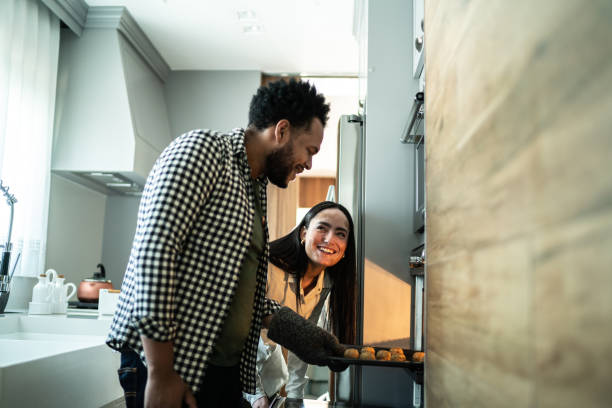 Couple looking bake food preparation into the oven at home