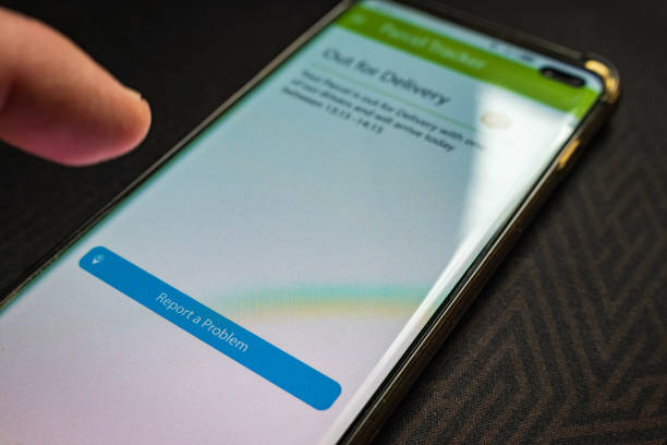 istock Male thumb finger over parcel delivery app on smartphone screen 1314982819