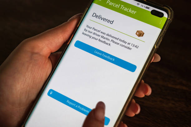 istock Male thumb finger over parcel delivery app on smartphone screen 1314982952