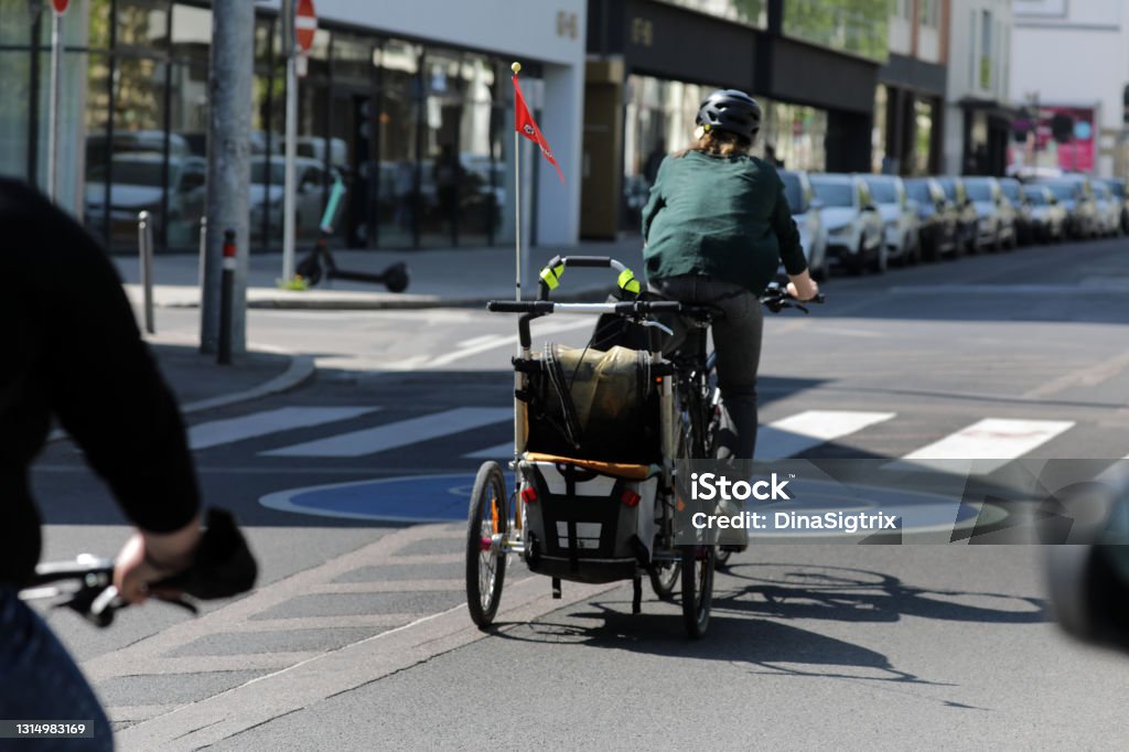 cyclists with load bike cyclists with trailers in the city Cargo Bike Stock Photo