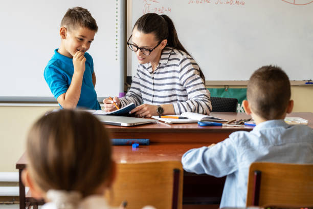 istock Female teacher helps her student to resolve mathematics assignment . 1314985476