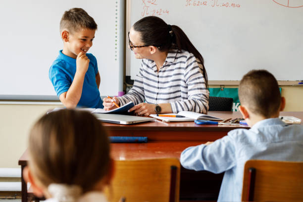 istock Female teacher helps her student to resolve mathematics assignment . 1314985630
