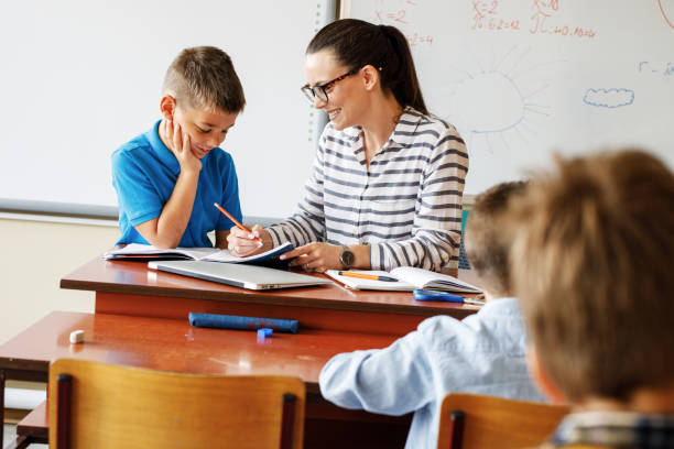 istock Female teacher helps her student to resolve mathematics assignment . 1314985715