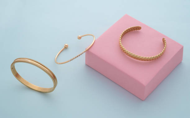 istock Three modern Golden bracelets collection on pink and blue background with copy space 1314987127