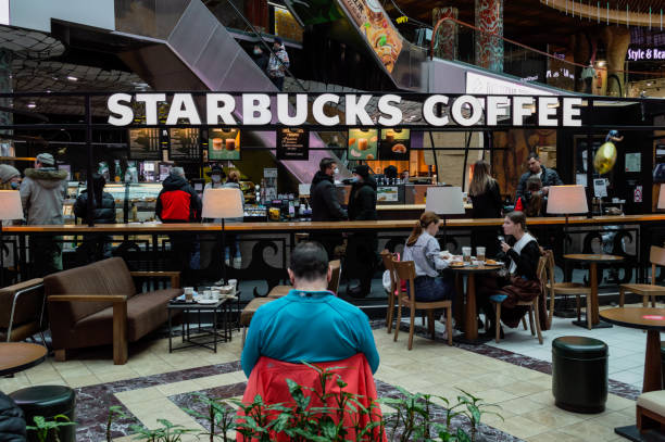 gente en las mesas en café starbucks. - starbucks coffee drink coffee cup fotografías e imágenes de stock