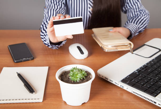 istock Woman holding  wallet with credit card on table. 1314990210