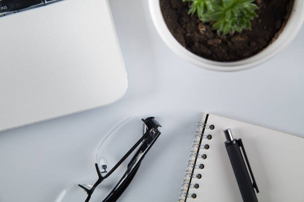 istock White office desk table with blank notebook, business supplies. Top view. 1314990263