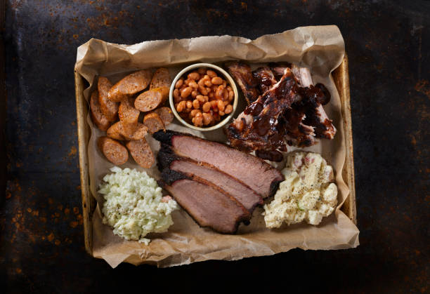 Smoked Meat Plater Dry Rubbed Beef Brisket with Pork Ribs, Chorizo Sausage, Baked Beans, Creamy Coleslaw and Potato Salad brisket photos stock pictures, royalty-free photos & images