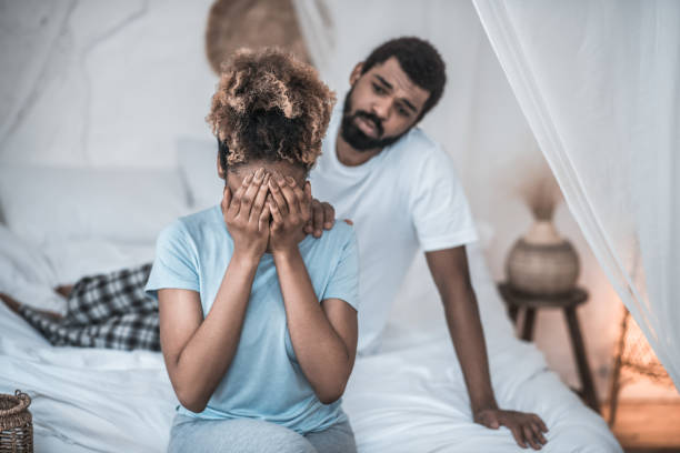 istock Woman covering her face with hands and man 1314994619