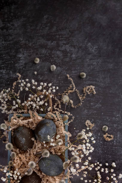 istock Easter composition with dark colored eggs in a wooden box. Willow branch. The minimal concept of Easter. 1314996805