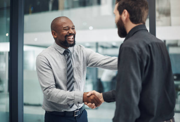 Shot of a mature businessman shaking hands with a colleague in a modern office Going to work feels like going home promotion employment stock pictures, royalty-free photos & images
