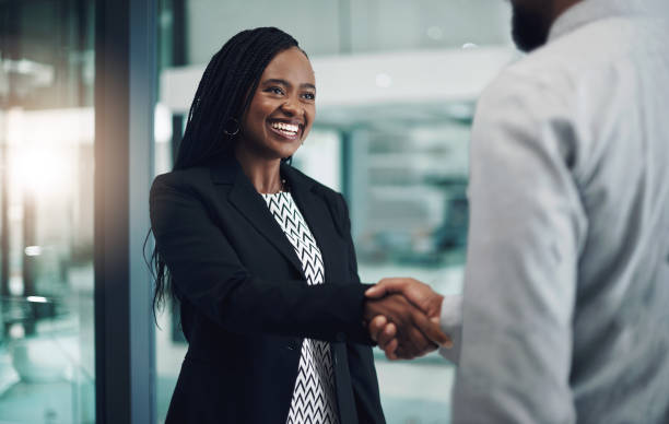 strzał młodej bizneswoman drżenie rąk z kolegą w nowoczesnym biurze - message communication sign african descent zdjęcia i obrazy z banku zdjęć