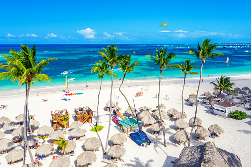 Beach vacation. Aerial drone view of tropical white sandy Bavaro beach in Punta Cana, Dominican Republic. Amazing landscape with palms, umbrellas and turquoise water of atlantic ocean.