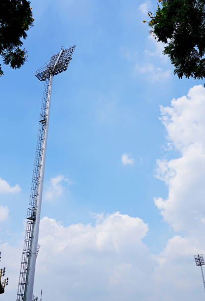 stadionlicht mit blauem himmel - floodlight blue sky day stock-fotos und bilder