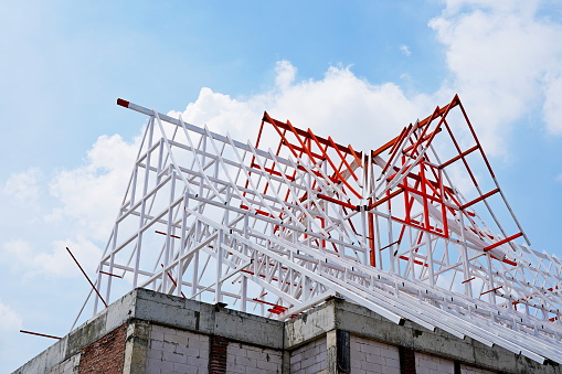 Steel roof frame for building construction on sky background