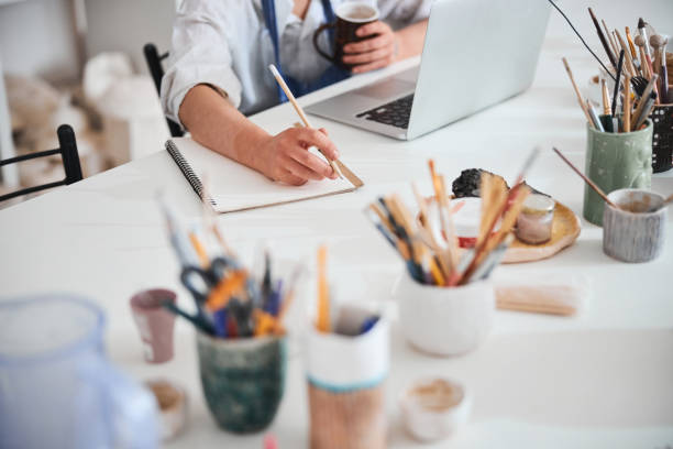 istock Person making notes in notepad at pottery shop 1315003287