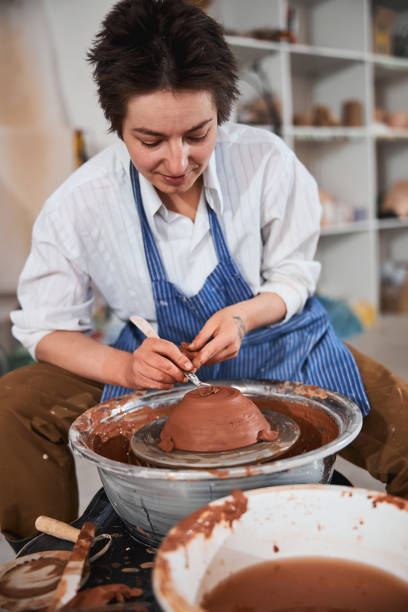 istock Woman ceramist peeling away clay layer from bowl 1315003340