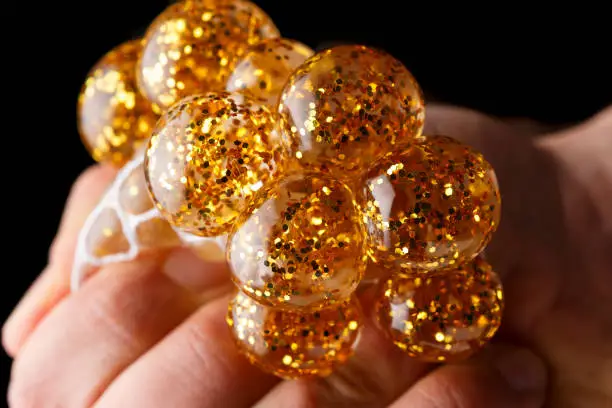 anti stress squishy mesh ball with golden glitter and hydro gel.