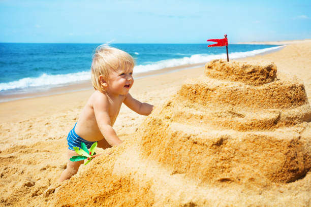 istock Cute handsome toddler climb on beach sand castle 1315010582