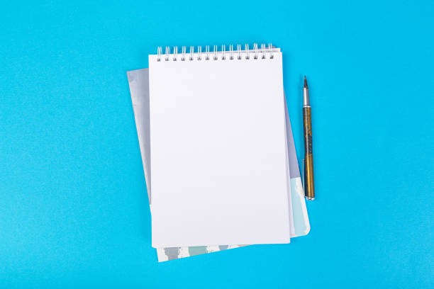 istock multiple school notepad on blue background, spiral notepad with blank page and ballpoint pen on table top view 1315010604