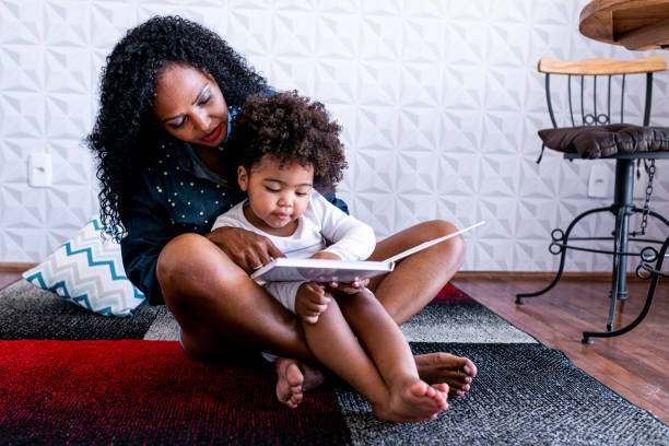 娘に児童書を読む母親 - child reading mother book ストックフォトと画像