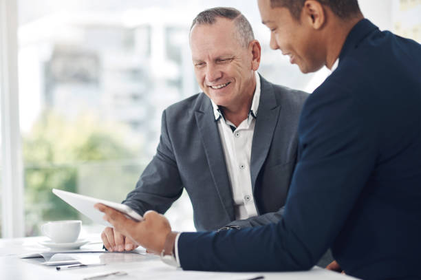 istock Shot of two businessmen using a digital tablet during a discussion in a modern office 1315012759