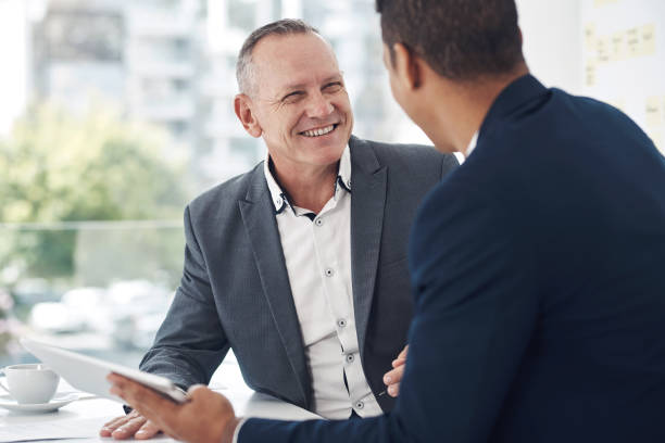 istock Shot of two businessmen using a digital tablet during a discussion in a modern office 1315012765