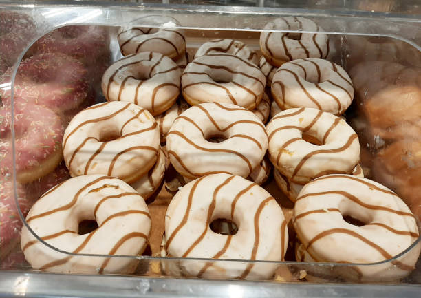 istock Donuts in the store's branch. Decorating doughnuts with icing. White glaze 1315013226