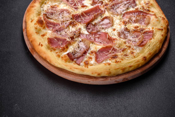 istock Delicious fresh crispy pizza from the oven with ham, cheese and basil 1315015660