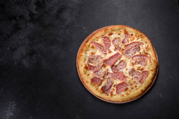 istock Delicious fresh crispy pizza from the oven with ham, cheese and basil 1315015691