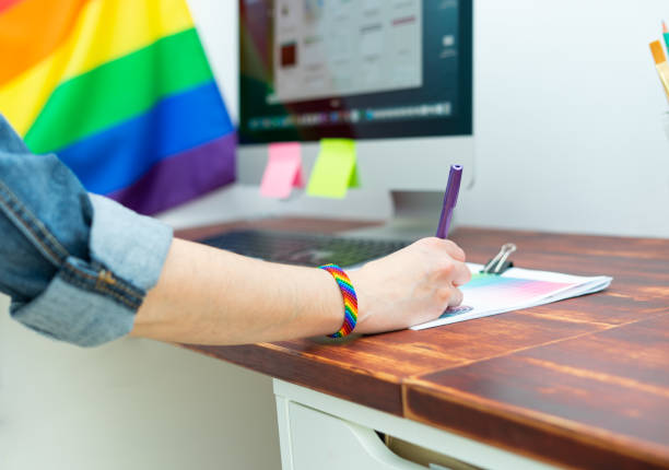 frau hand arbeiten im büro mit lgbt-dekor und accessoires. cultura lgbtqia - gay pride flag gay pride gay man homosexual stock-fotos und bilder