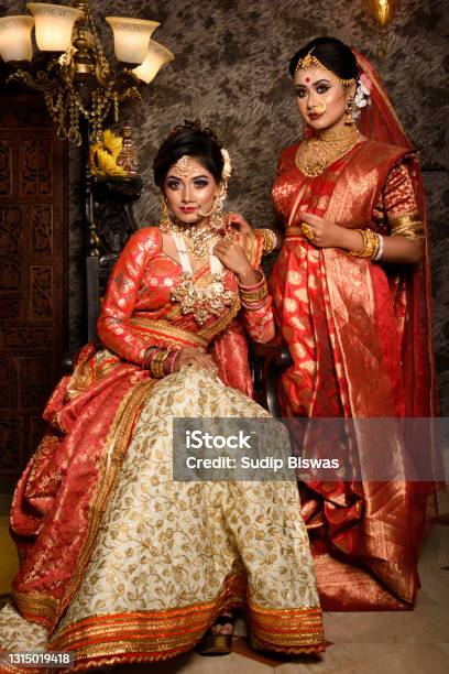Magnificent Young Indian Brides In Luxurious Bridal Costume With Makeup And Heavy Jewellery With Classic Vintage Interior In Studio Lighting Wedding Lifestyle And Fashion Stock Photo - Download Image Now